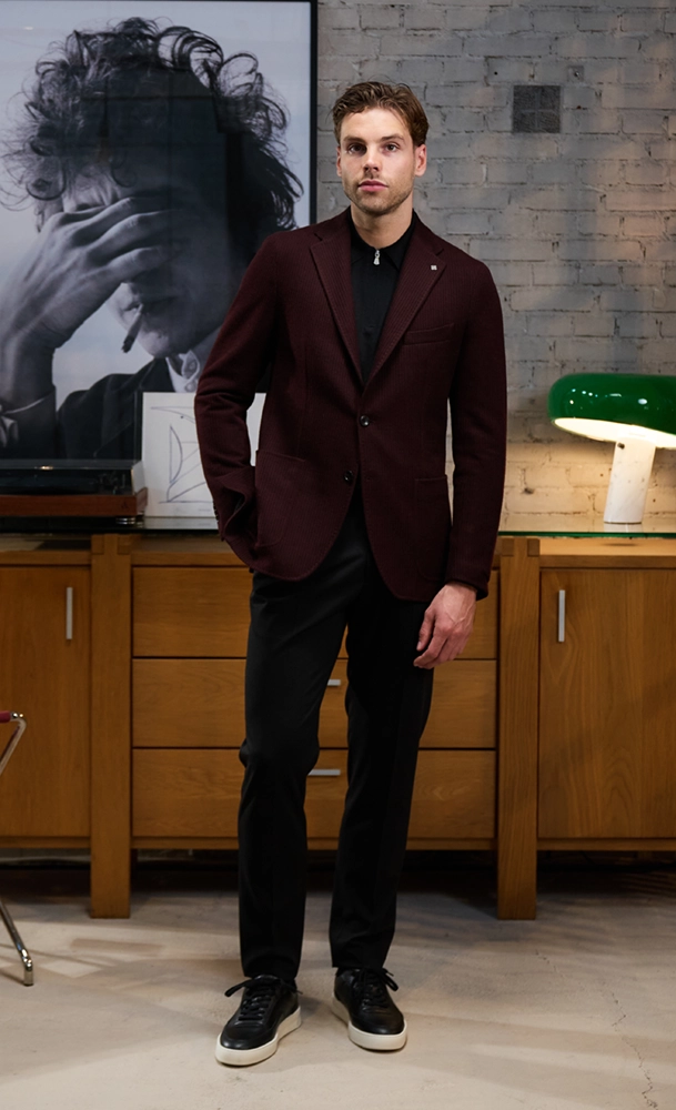 Mannelijk model in zwarte broek en bordeaux Tagliatore Colbert