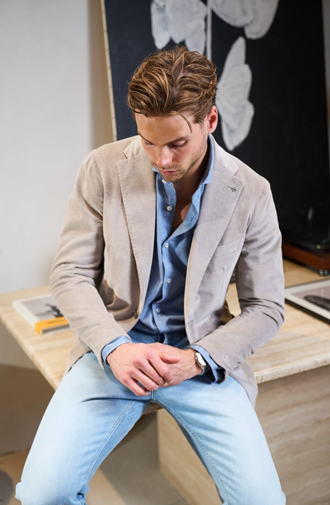 Mannelijk model in jeans en beige Tagliatore Colbert